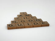 a wooden scrabble with words that read i am the good guide