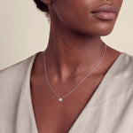 Load image into Gallery viewer, Model wearing the Round Brilliant Rubover Diamond Pendant, Low Set on a fine chain