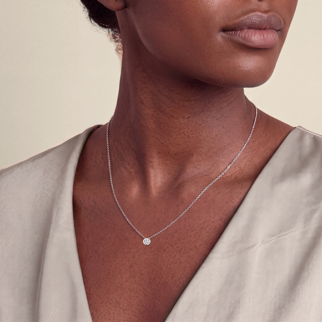 Model wearing the Round Brilliant Rubover Diamond Pendant, Low Set on a fine chain