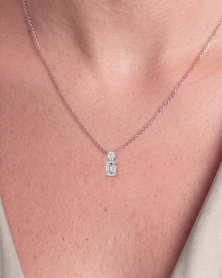 Emerald Cut Diamond Pendant with Small Round Diamond worn – close-up on the collarbone