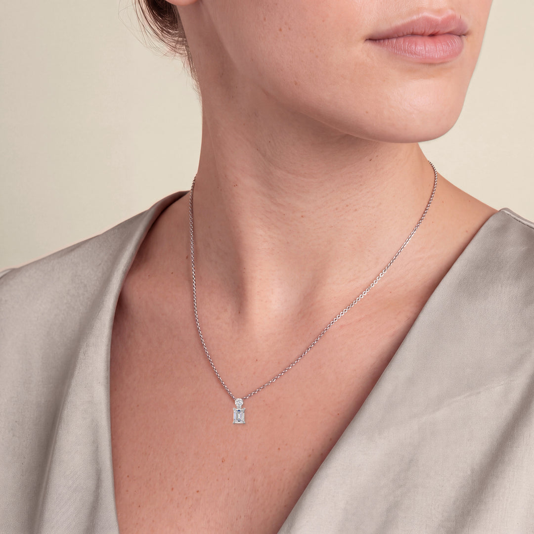 Model wearing the Emerald Cut Diamond Pendant with Small Round Diamond on a fine chain