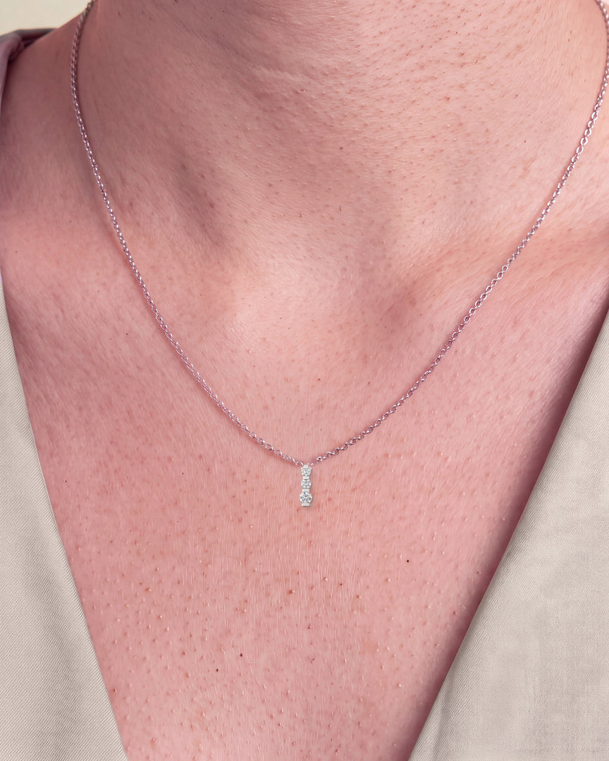 Three Stone Diamond Pendant worn – close-up on the collarbone